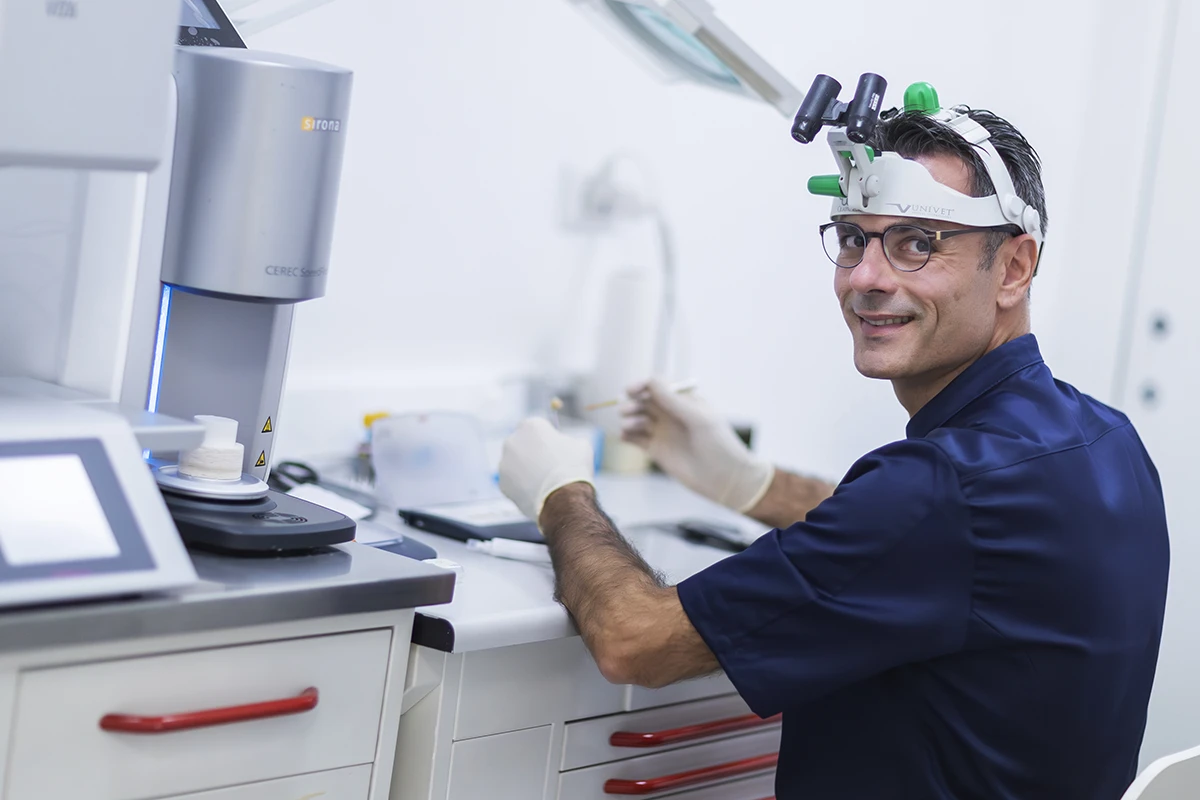 Dottor Giuliodori 
                prepara una protesi dentaria su un tavolo operatorio, con strumenti odontoiatrici e materiali 
                protesici ben organizzati.