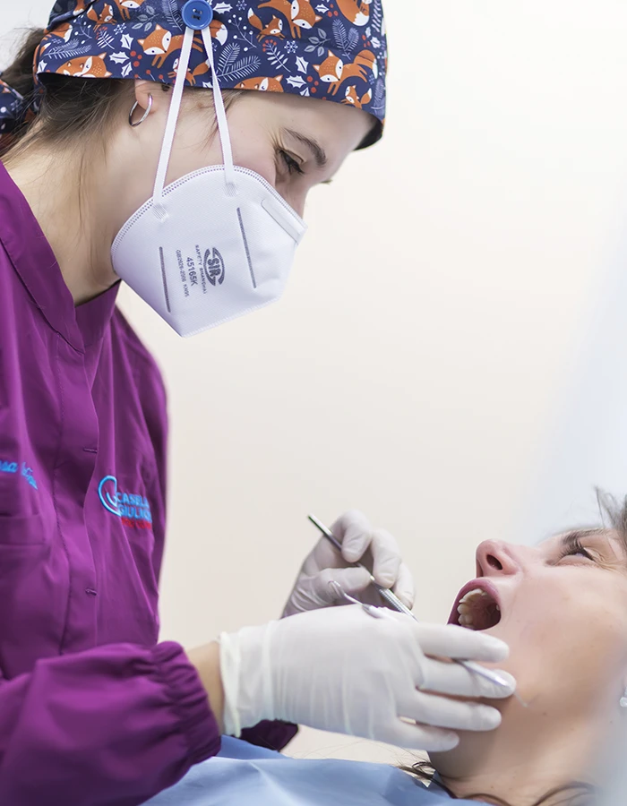 Igienista dentale che esegue una pulizia dei denti senza dolore